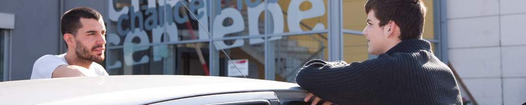 Jugendlicher und Betreuer am Parkplatz
