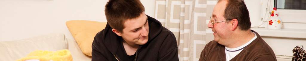 Kunde in seiner eigenen Wohnung im Gespräch mit einem Betreuer