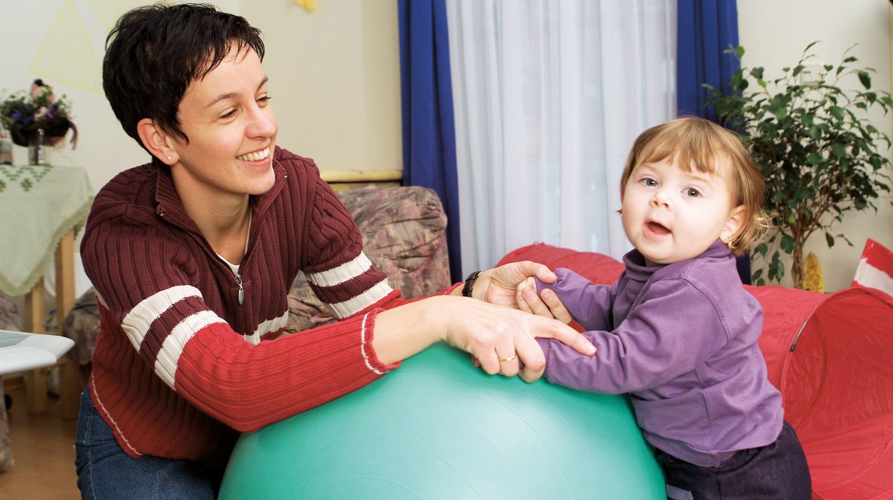 Kinder-Jugendliche-Familie_Jugend-am-Werk-Steiermark Eine Frau spielt mit einem circa zweijährigen Kind in einer Wohnung