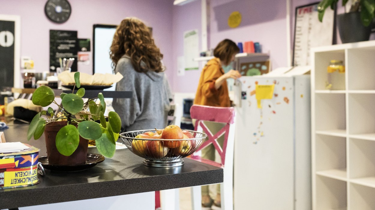 ein Mädchen und eine Dame stehen in einer schön eingerichteten lila Küche