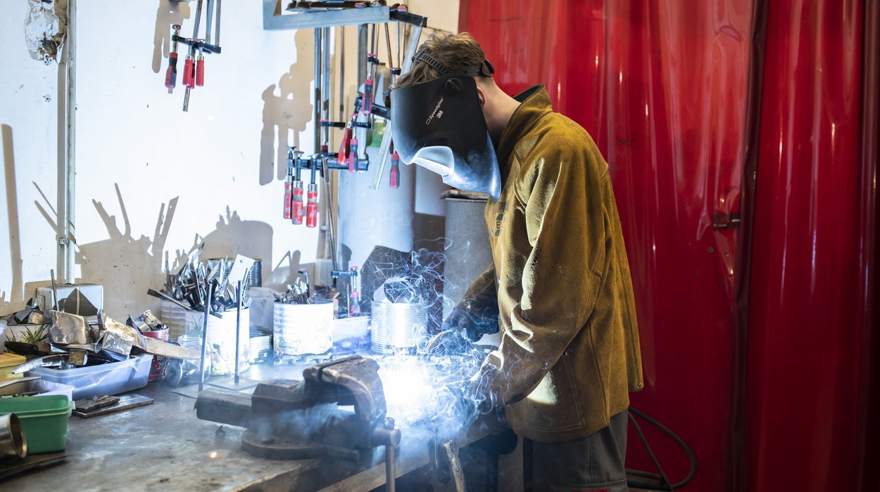 Ein Jugendlicher schweißt in einer Metallwerkstätte