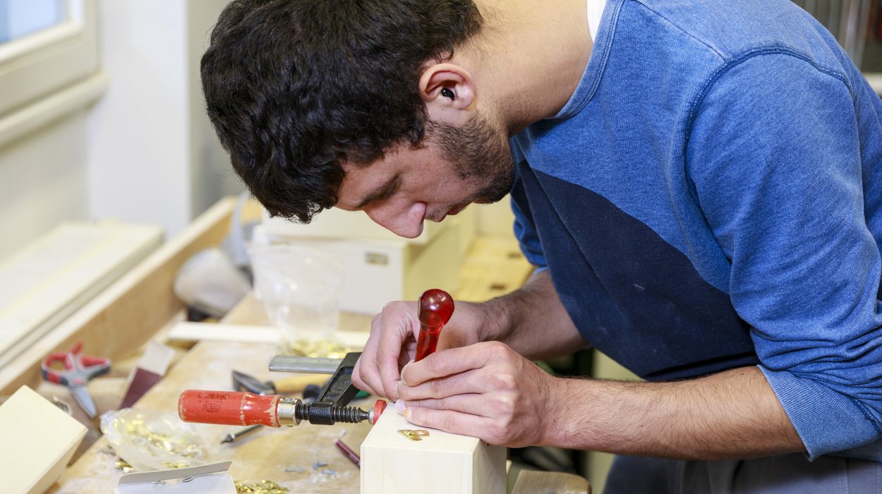 Service-fuer-Unternehmen_Jugend-am-Werk-Steiermark Ein Mann mit Behinderung arbeitet an einer Werkbank