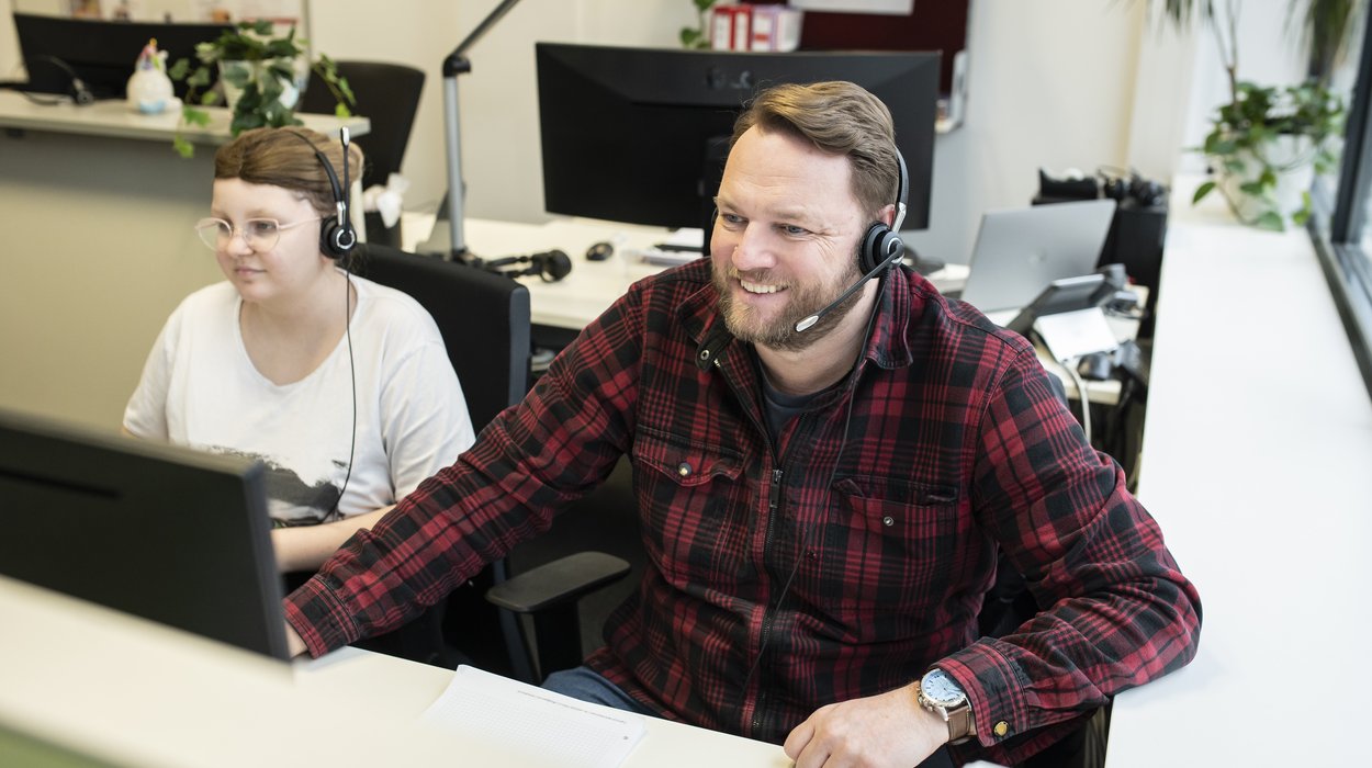 Ein Mann und eine Frau mit Behinderung arbeiten an einem Computer