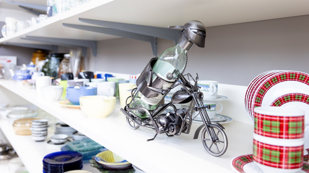 Detailansicht_re-use-shop-Feldbach_Jugend-am-Werk-Steiermark Detailansicht eines Regals mit Tassen und Tellern.