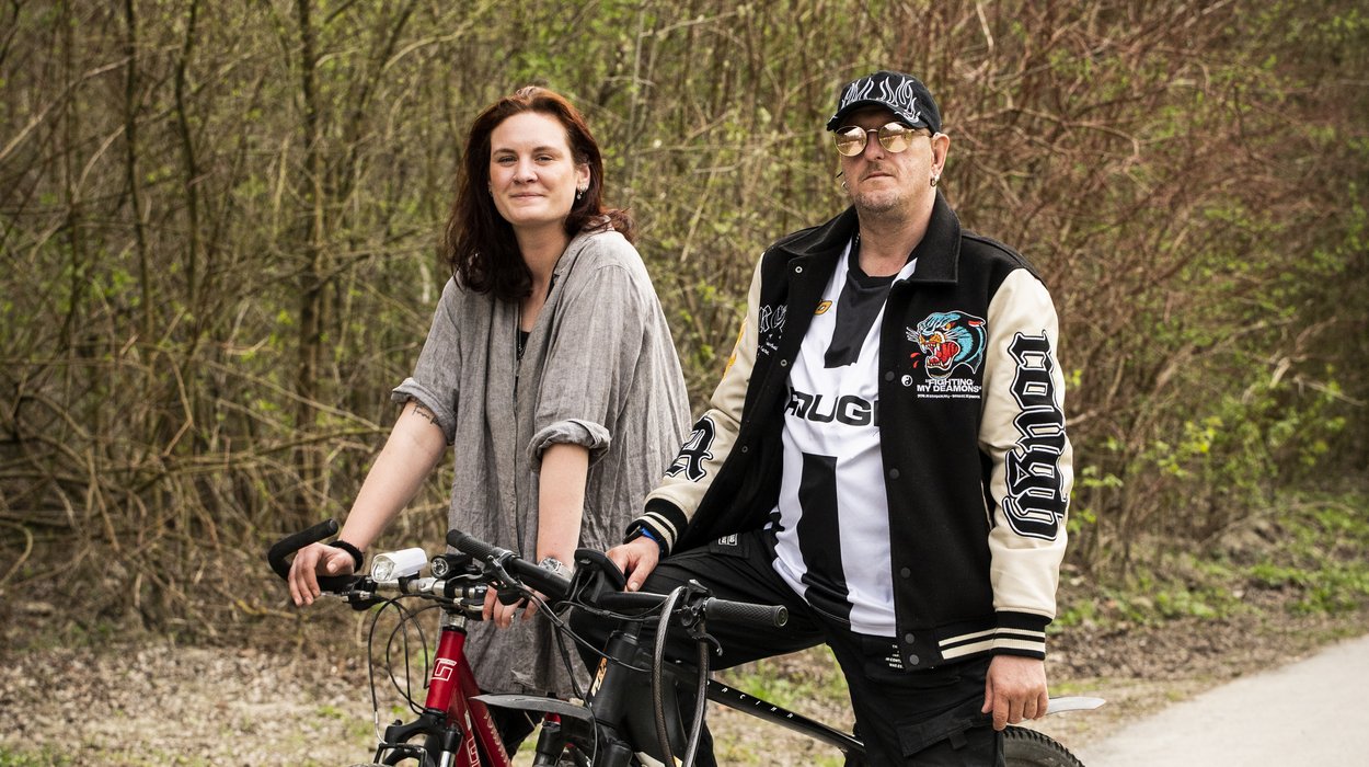 Eine Frau und ein Mann mit Behinderung fahren gemeinsam Rad