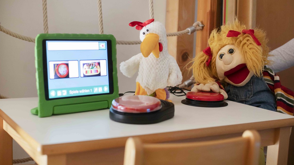 Eine Spielzeuge und ein Bildschirm Apps für Frühförderung von Kindern auf einem Tisch