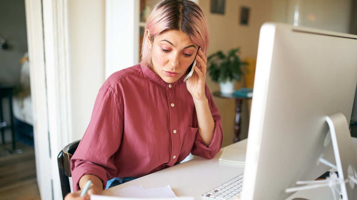Eine Frau sitzt vor einem Computer und nimmt Telefonanrufe entgegen