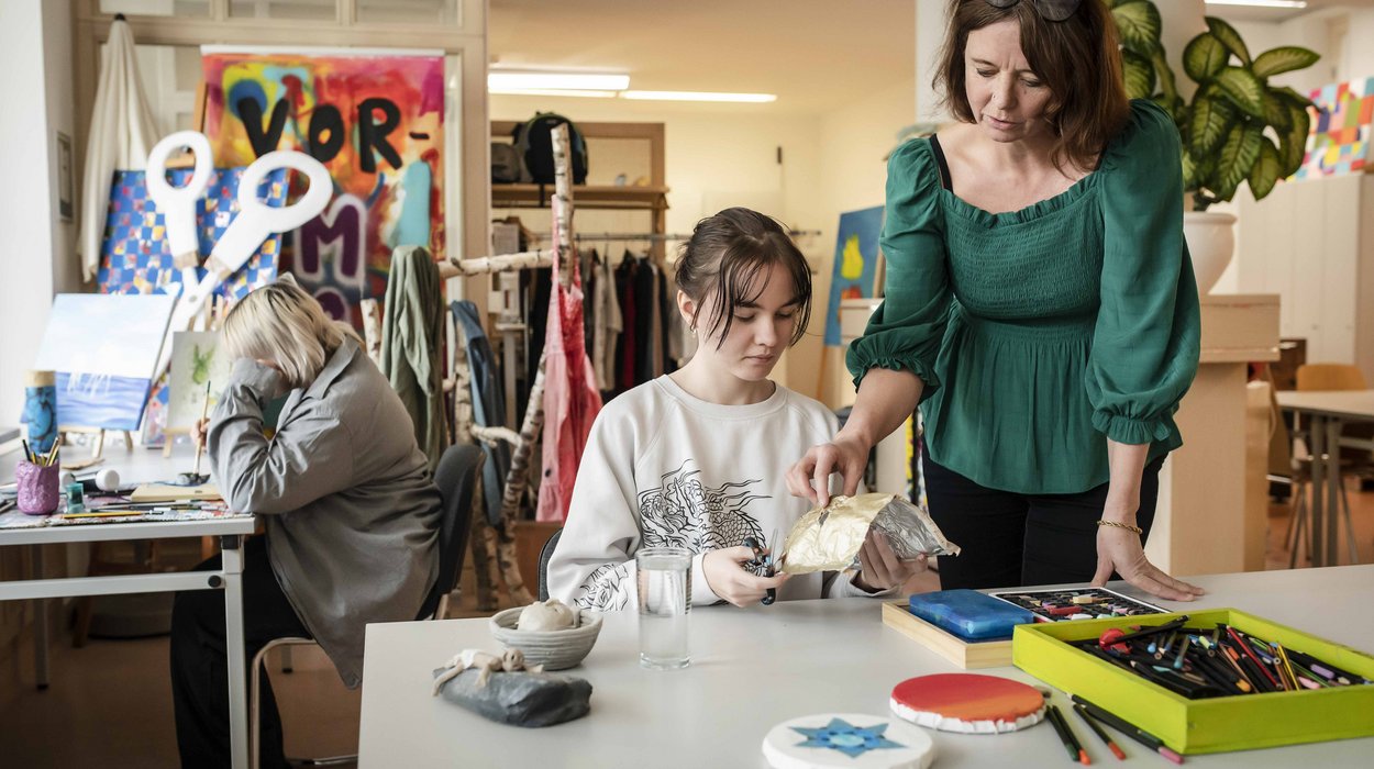 AusbildungsFit-Deutschlandsberg_Jugend-am-Werk-Steiermark Eine Frau steht neben einer an einem Tisch sitzenden Jugendlichen.