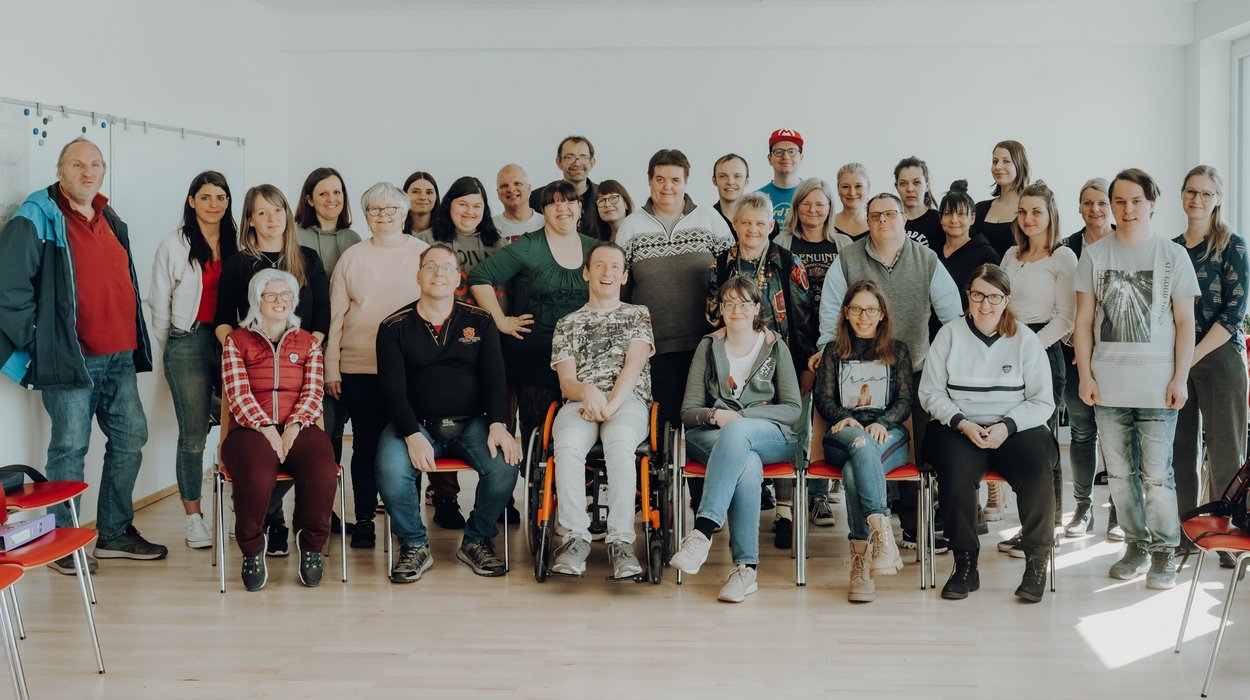 Interessensvertretung_Jugend-am-Werk-Steiermark Eine große Gruppe Menschen mit Behinderung in einem hellen Raum