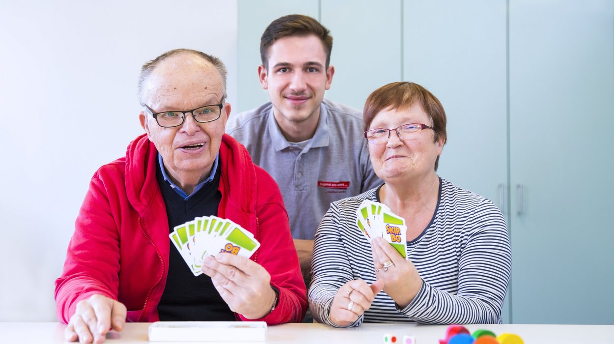 Freiwilliges-soziales-Jahr_Jugend-am-Werk-Steiermark Ein Zivildiener mit einem älteren Mann und einer älteren Frau mit Behinderung.