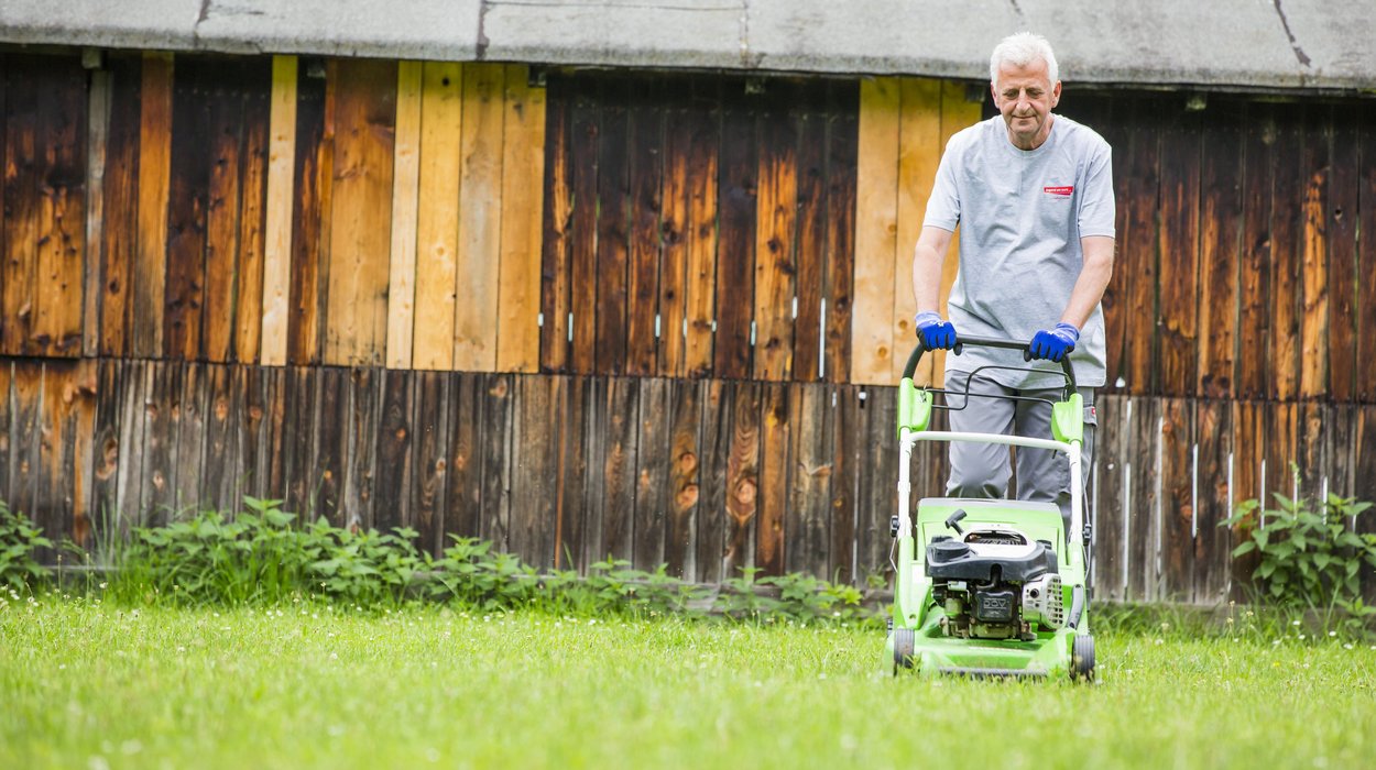 Gemeinnuetzige-Beschaeftigung_Jugend-am-Werk-Steiermark Mann mäht den Rasen.