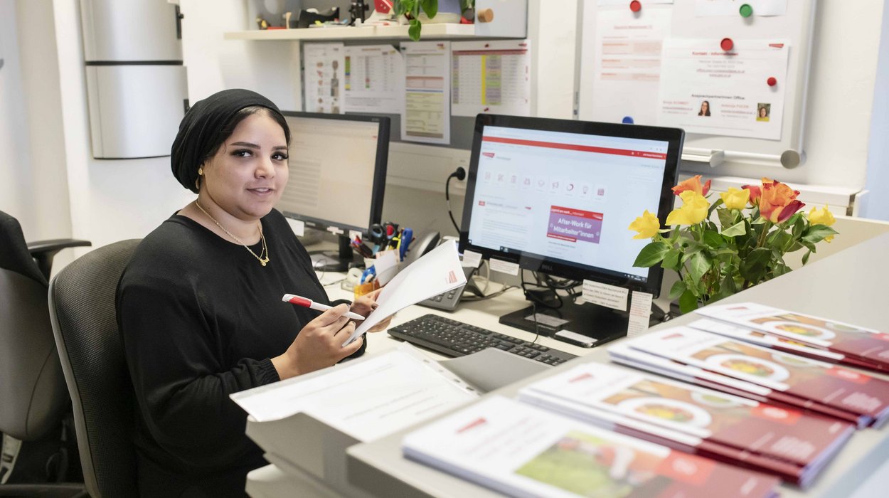 Officedienste_Jugend-am-Werk-Steiermark Frau sitzt vor einem Computer am Empfang in einem Büro.