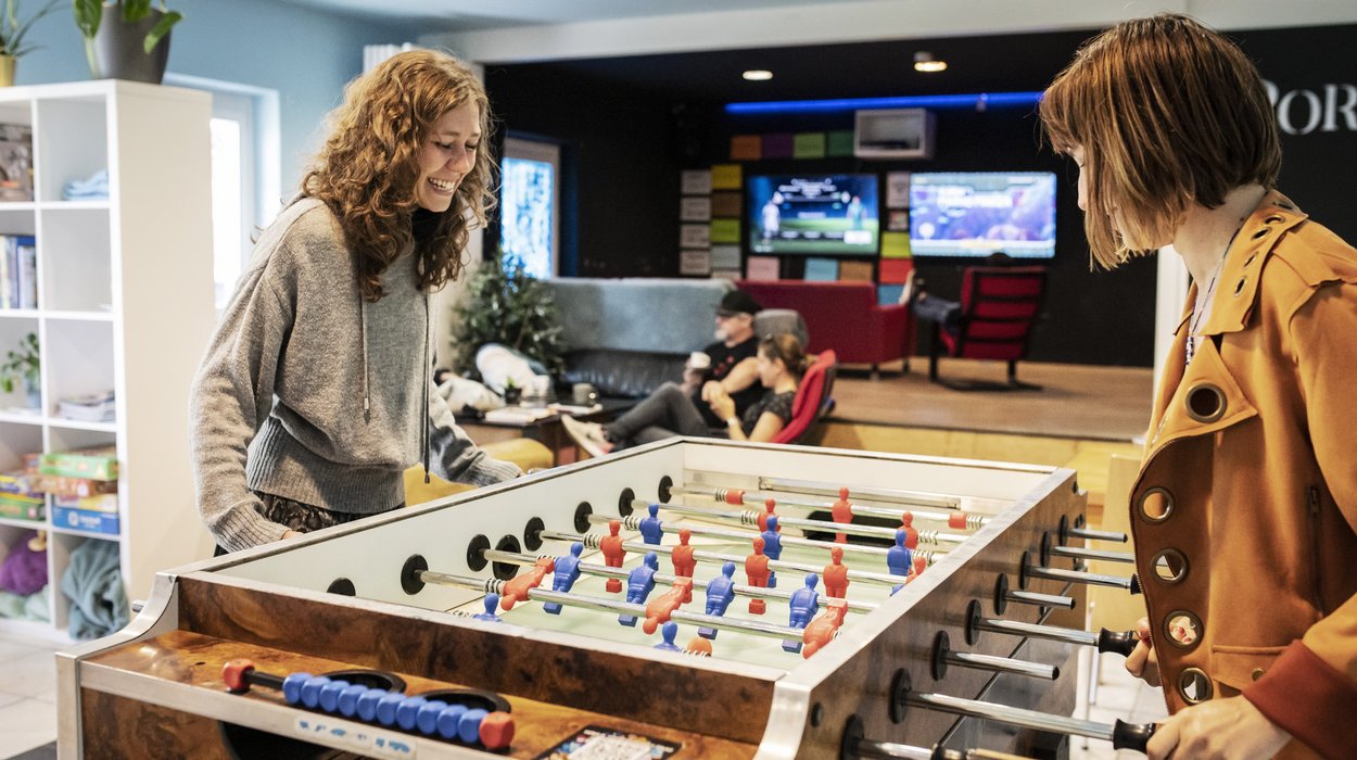 zwei Mädchen spielen Drehfußball in einem Freizeitraum