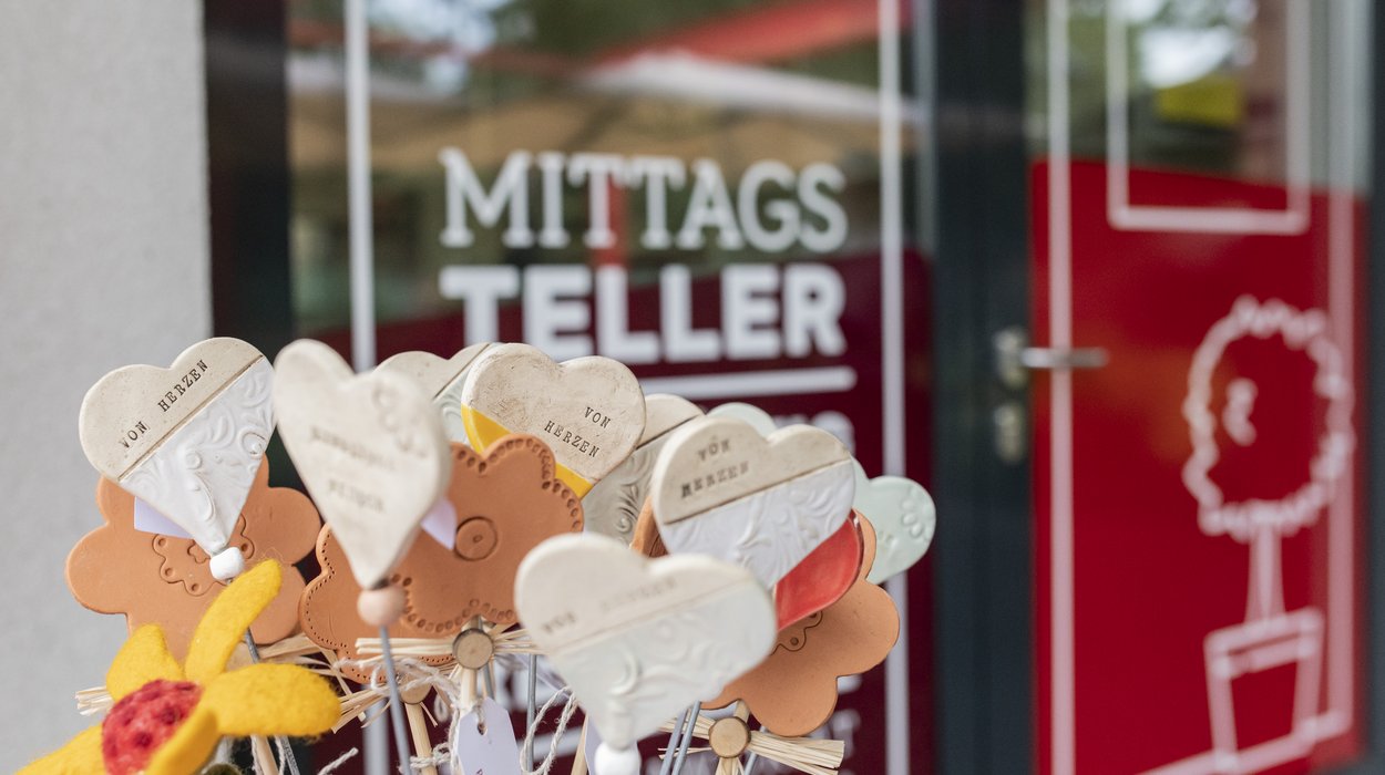 Ladencafe_Jugend-am-Werk-Steiermark Ein Strauß Tonherzen vor der Glasfront des Ladencafe.