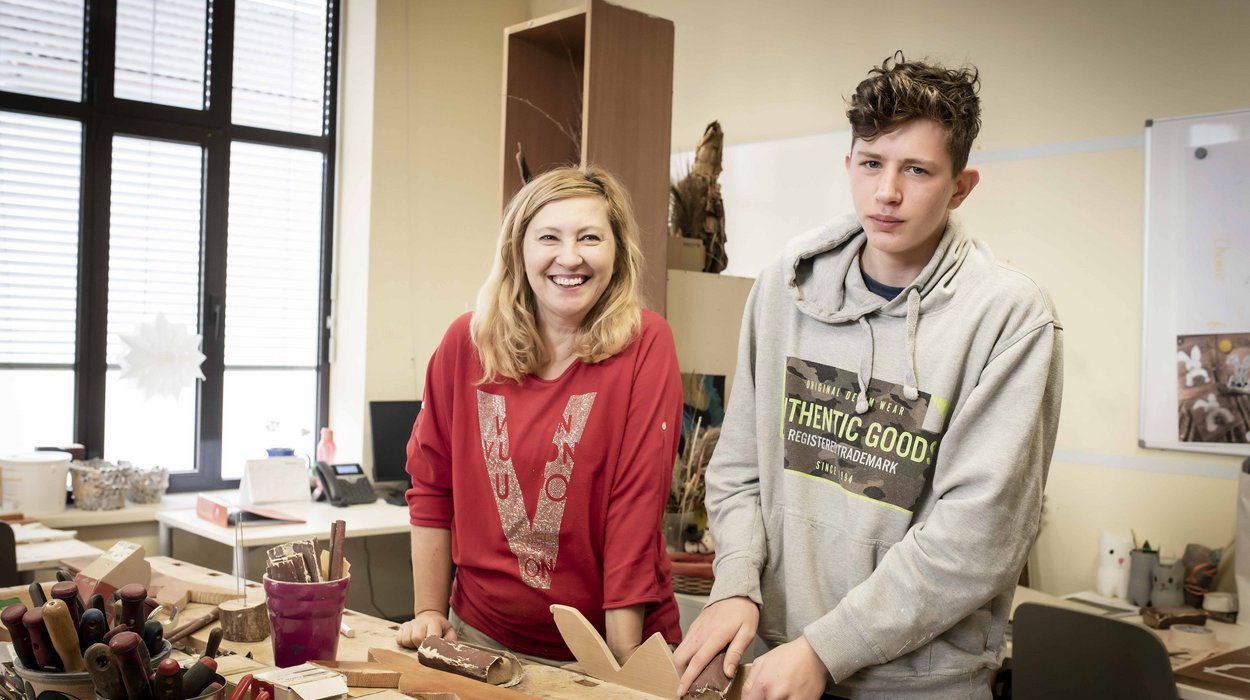 AusbildungsFit_Deutschlandsberg_Jugend-am-Werk-Steiermark Eine Frau und ein Jugendlicher an einem Tisch, wo Holzarbeiten erledigt werden
