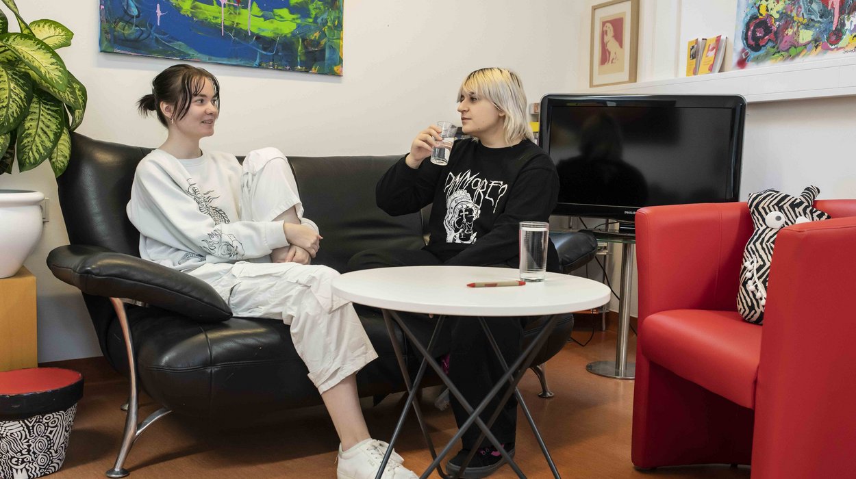 AusbildungsFit_Deutschlandsberg_Jugend-am-Werk-Steiermark Zwei Jugendliche sitzen auf einem Sofa und unterhalten sich miteinander